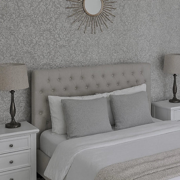 Gray upholstered bed with matching pillows in a bedroom setting.