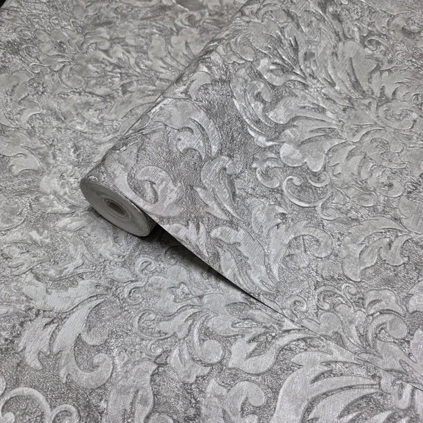 Roll of decorative wallpaper with intricate patterns on a textured surface.